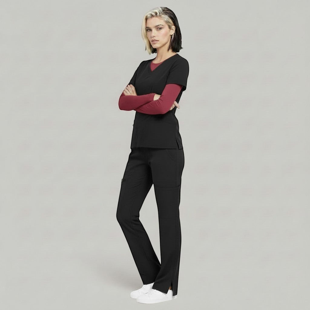 Model wearing Élaura Faye black cargo pants and matching scrub top with a maroon long-sleeve base layer