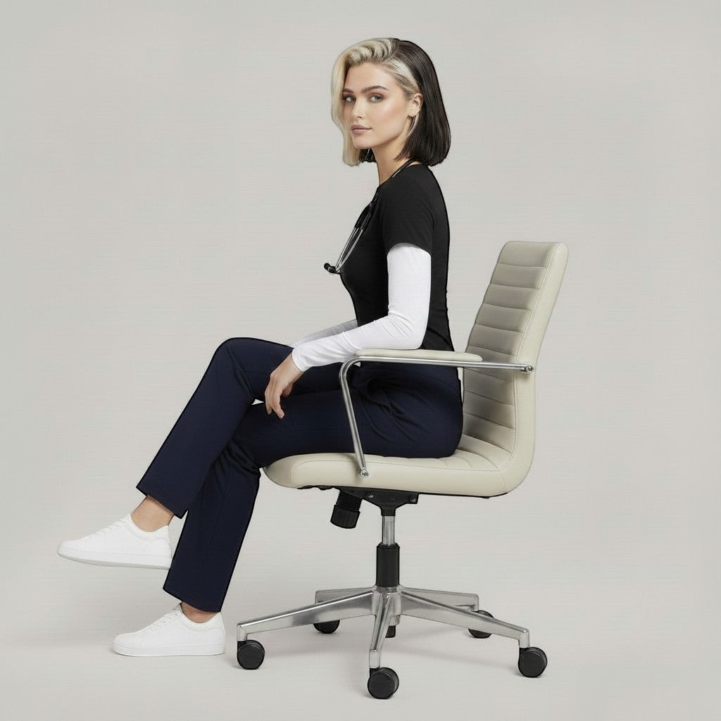 Élaura Faye cargo pants in navy blue worn by a woman sitting in a modern office chair with a black top and sneakers.